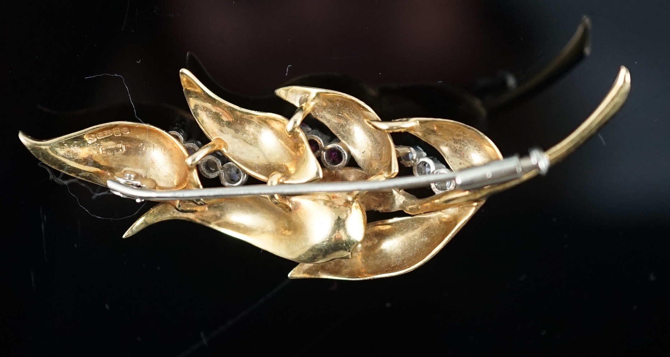 A 1960's 18ct gold, six stone ruby and seven stone diamond chip set leaf spray brooch